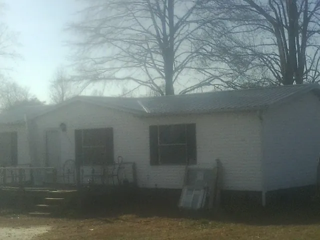 New metal roof on a white painted brick home on a foggy morning in Lawrence